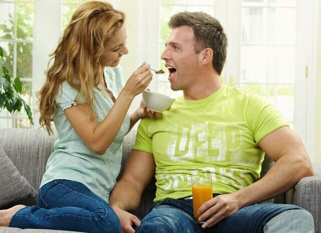 La mujer alimenta al hombre con productos para aumentar la potencia.